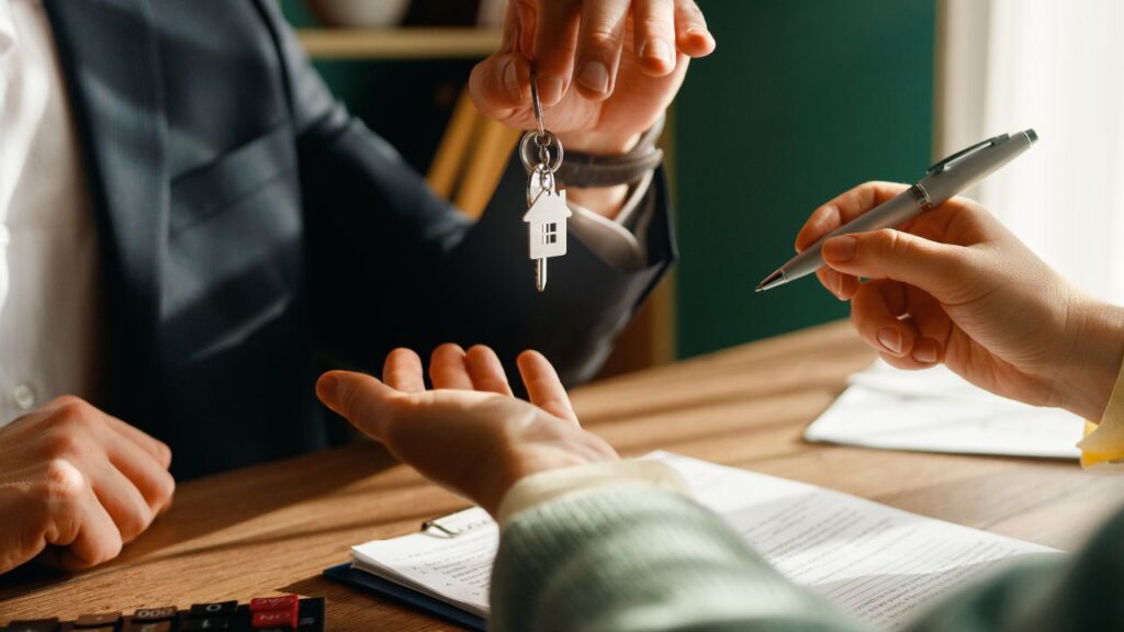 Tenant receiving rental keys during a lease signing, representing tenant retention and reduced turnover