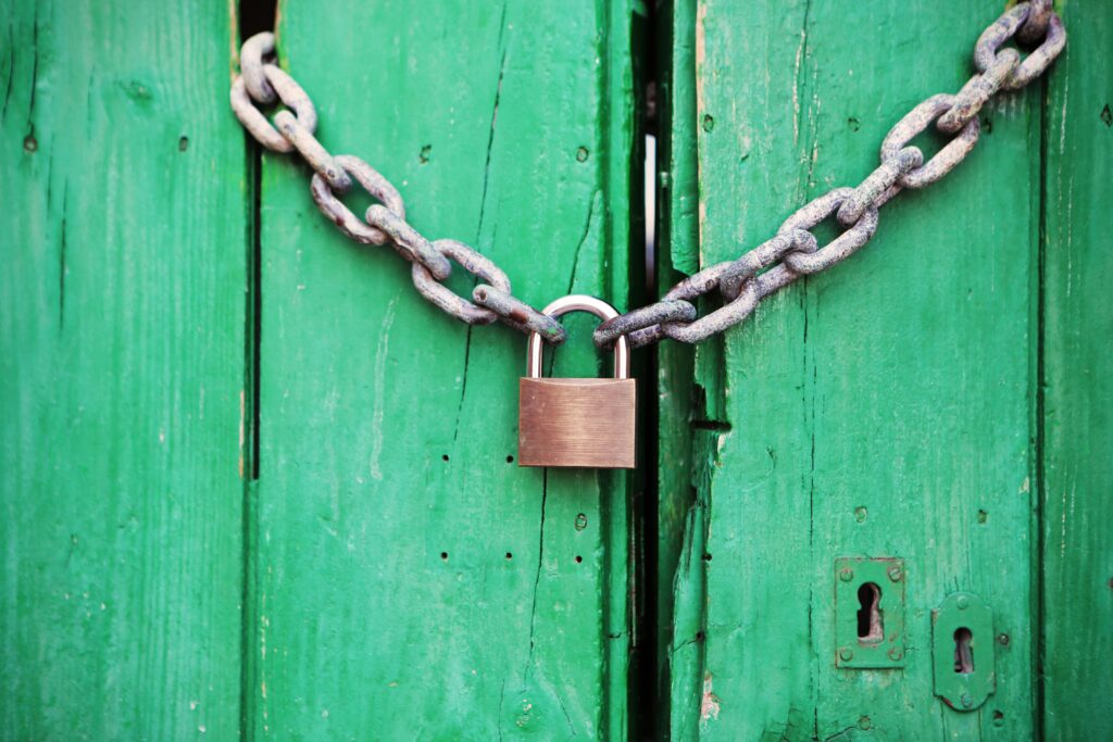 A lock on a green wooden door.