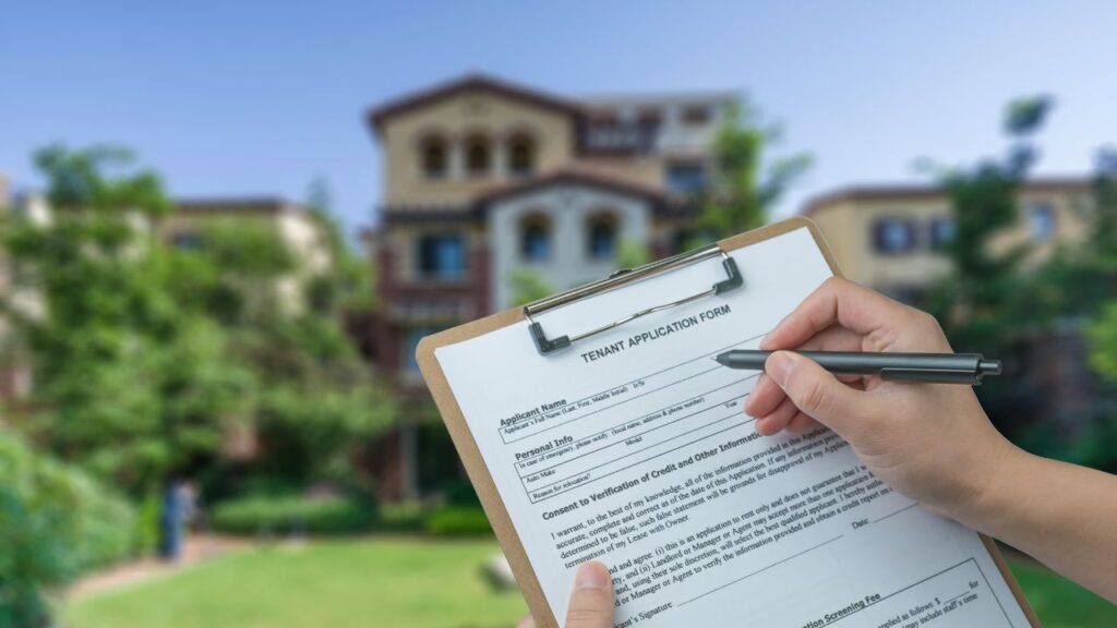 Rental application form being reviewed in front of an apartment building