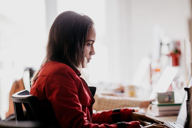 a person sitting at their desk and using a laptop