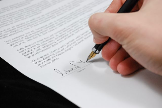 a person signing a mock contract