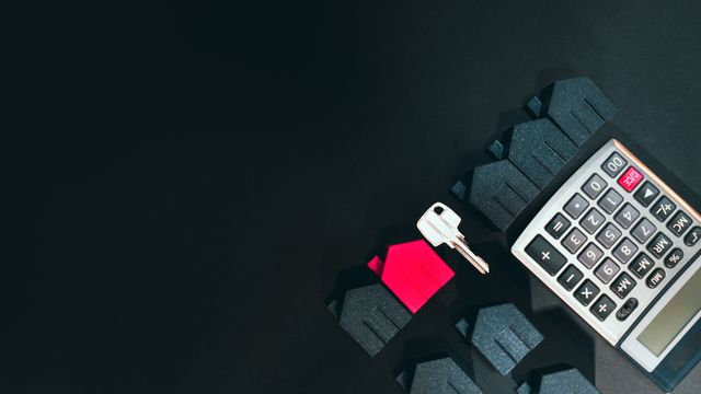 a house key, calculator, and miniature house models